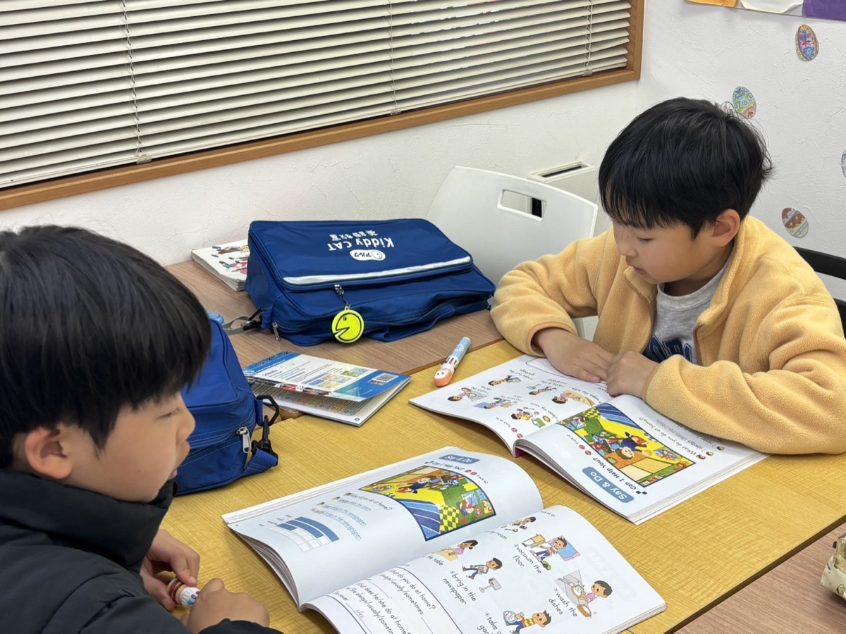 英語のテキストを開いて学習する子どもたち