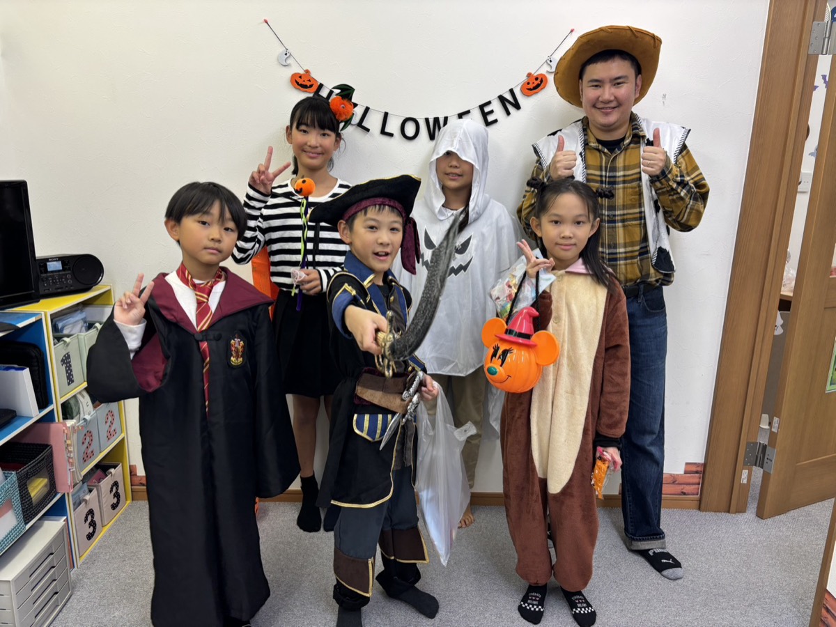 ハロウィンの仮装をした子どもたちと講師の集合写真