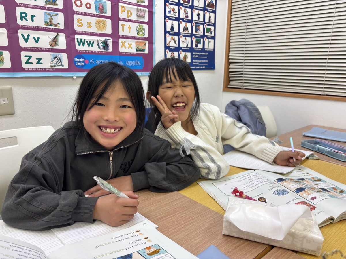 テキストを広げて笑顔を見せる子どもたち
