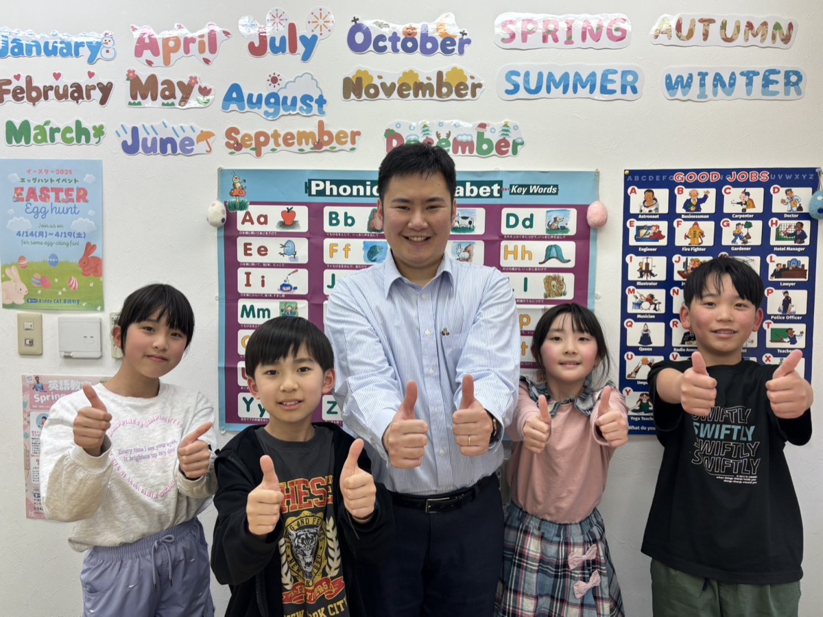 講師と子どもたちが、そろってグッドサインをしている様子