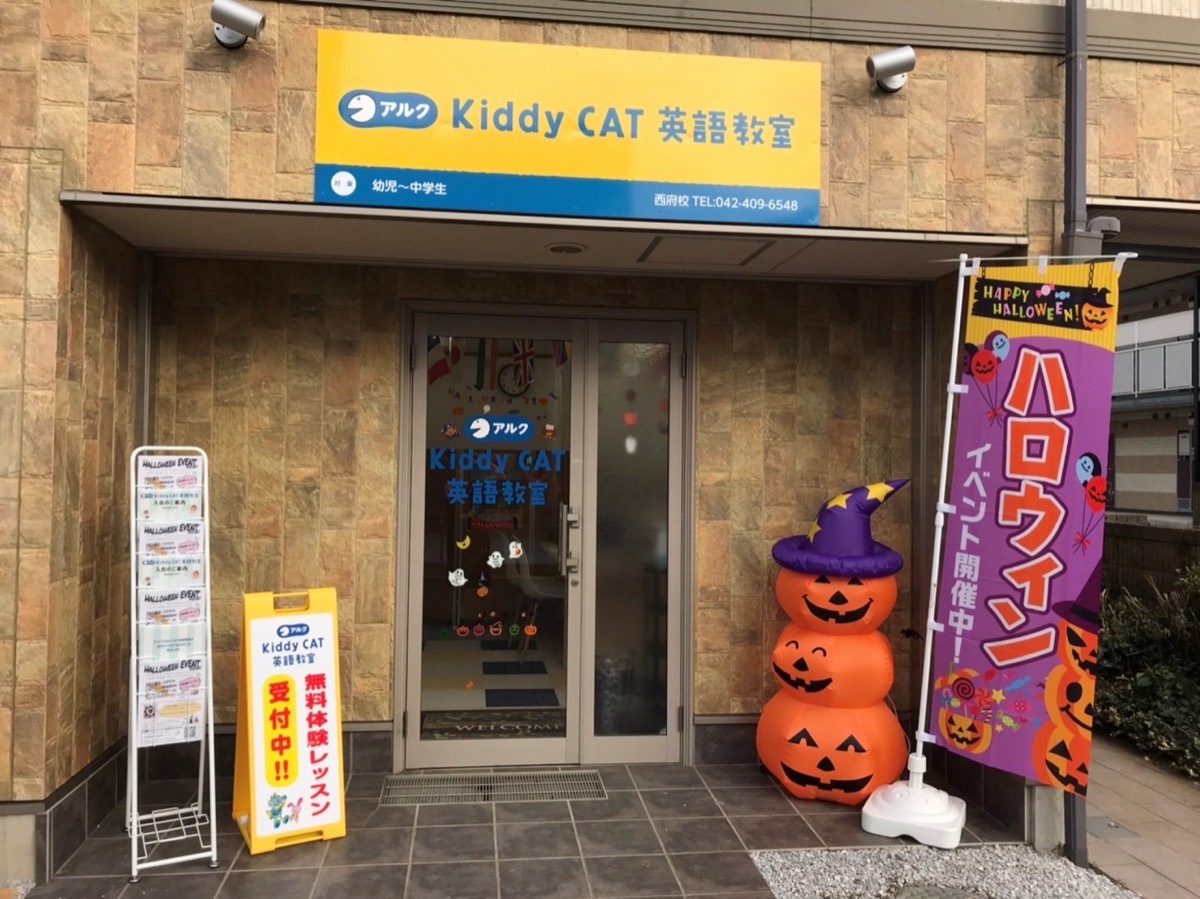 アルク Kiddy CAT英語教室 西府校の入口。黄色い看板とハロウィンの飾りつけ