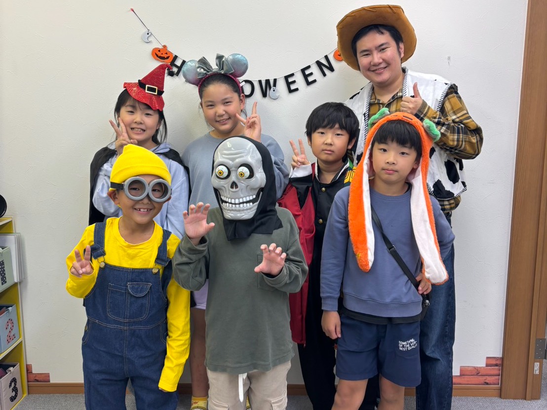 ハロウィンの仮装をした子どもたちと講師の集合写真